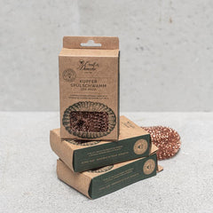 Kraft packaging with copper dish scrubber on a gray background