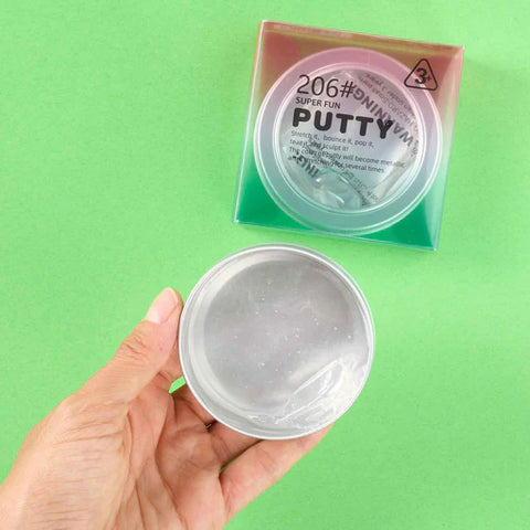 Hand holding a container of putty with packaging labeled 'Super Fun Putty' on a green background